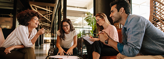 Four businesspeople talking in an office meeting